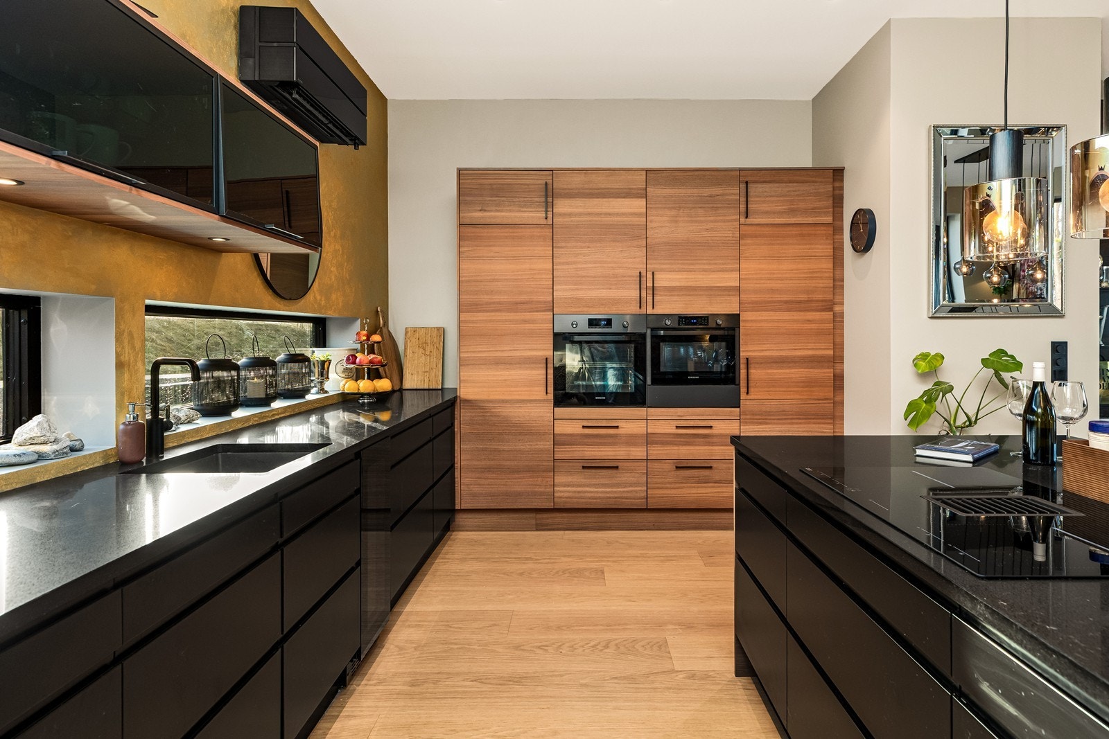 Kjøkkeninnredning med slette fronter, praktiske skuffer og en sort luft-til-luft varmepumpe Galleribilde