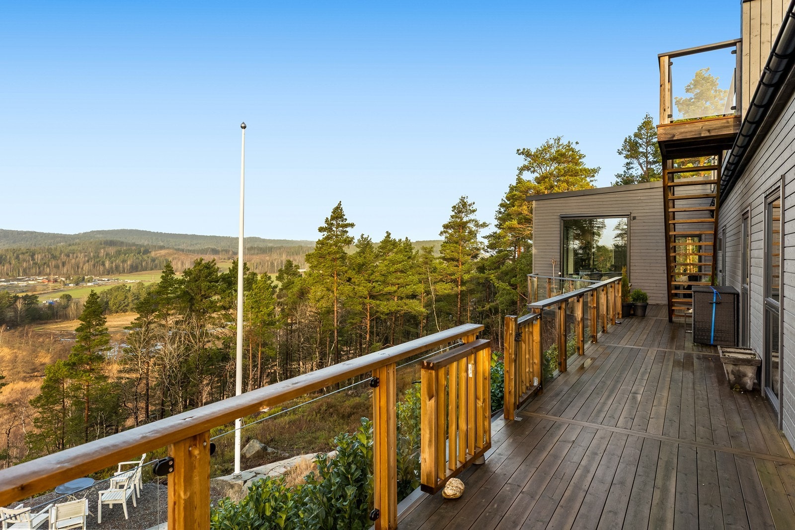 Veranda på fremsiden av boligen med trappegang ned til egen bålplass Galleribilde