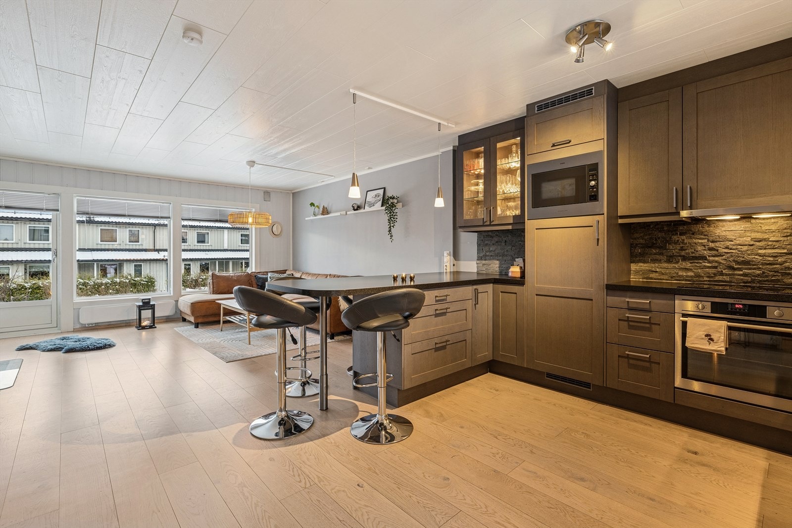 Lekkert kjøkken med profilerte fronter og laminert benkeplate med kjøkkenkum. Flislagt og belysning over benkeplate. Galleribilde