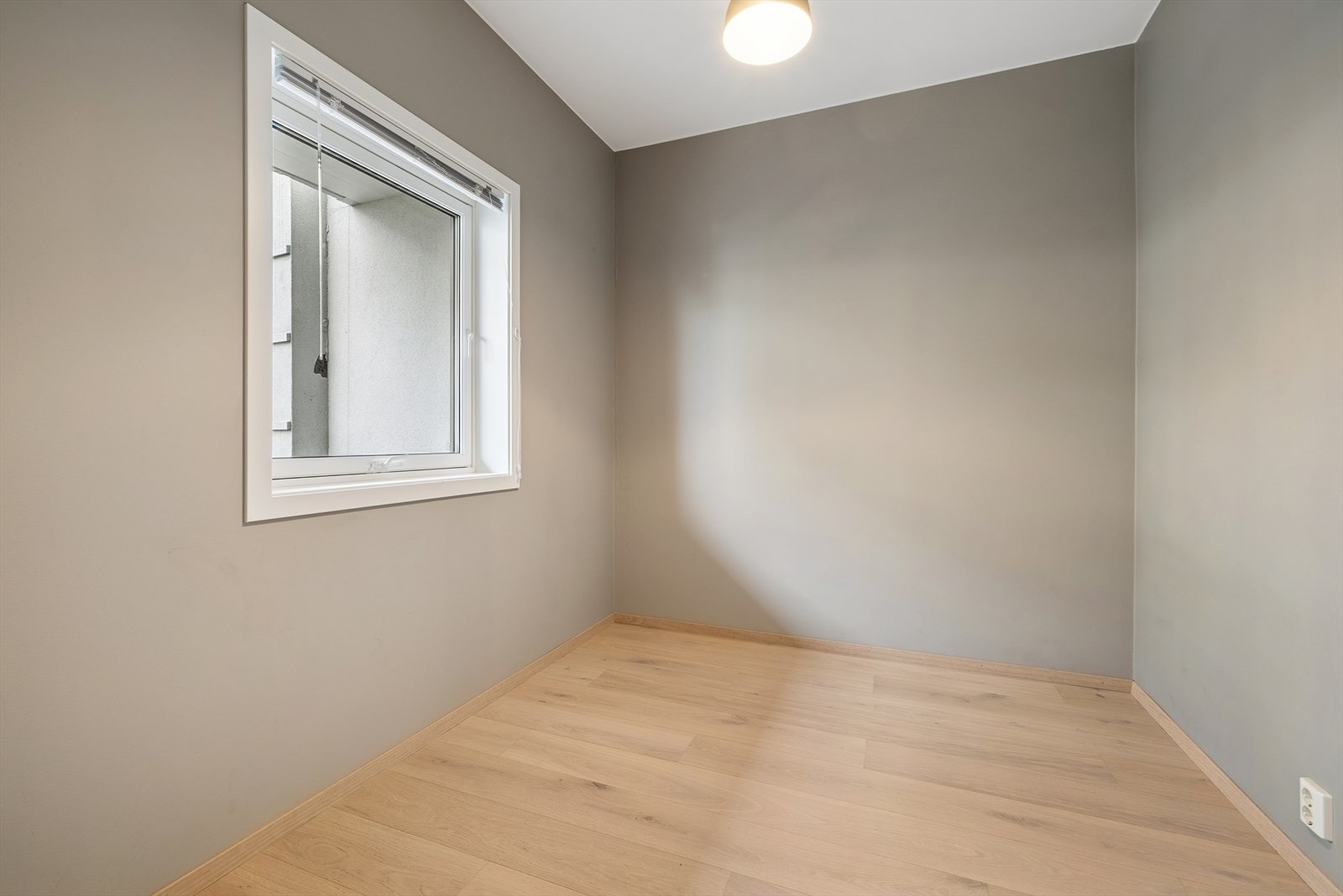 Fra entréen har du tilgang til ett av leilighetens to romslige soverom. Rommet egner seg perfekt som barnerom, gjesterom eller et praktisk hjemmekontor. Galleribilde