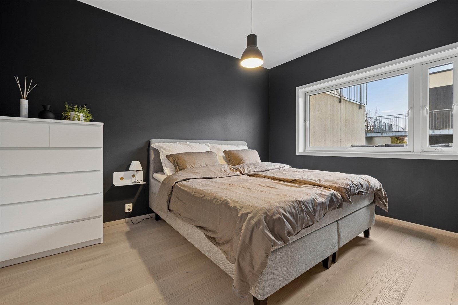 Hovedrommet er romslig med plass til stor dobbeltseng og tilhørende oppbevaringsmøbler. Et stort vindu slipper inn rikelig med lys og gir utsikt mot nærområdet. Galleribilde