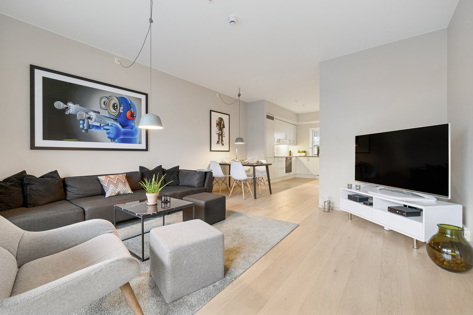 Lys og moderne stue med åpen løsning mot kjøkken - perfekt for både hverdag og sosiale sammenkomster. Galleribilde