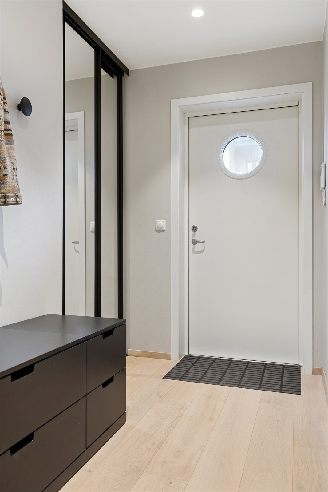 Adkomst skjer via både heis og trapp, og du ønskes velkommen inn i en lys og innbydende entré. Her er det god plass til oppheng av yttertøy, samt en praktisk skyvedørsgarderobe med speildører som gir både oppbevaring og et elegant uttrykk. Galleribilde
