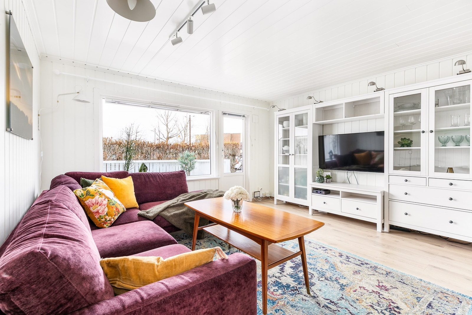 Stuens store vindu sikrer gode lysforhold. Hekken rundt hagen begrenser innsyn. Terrassedøren er fa 2009. Galleribilde