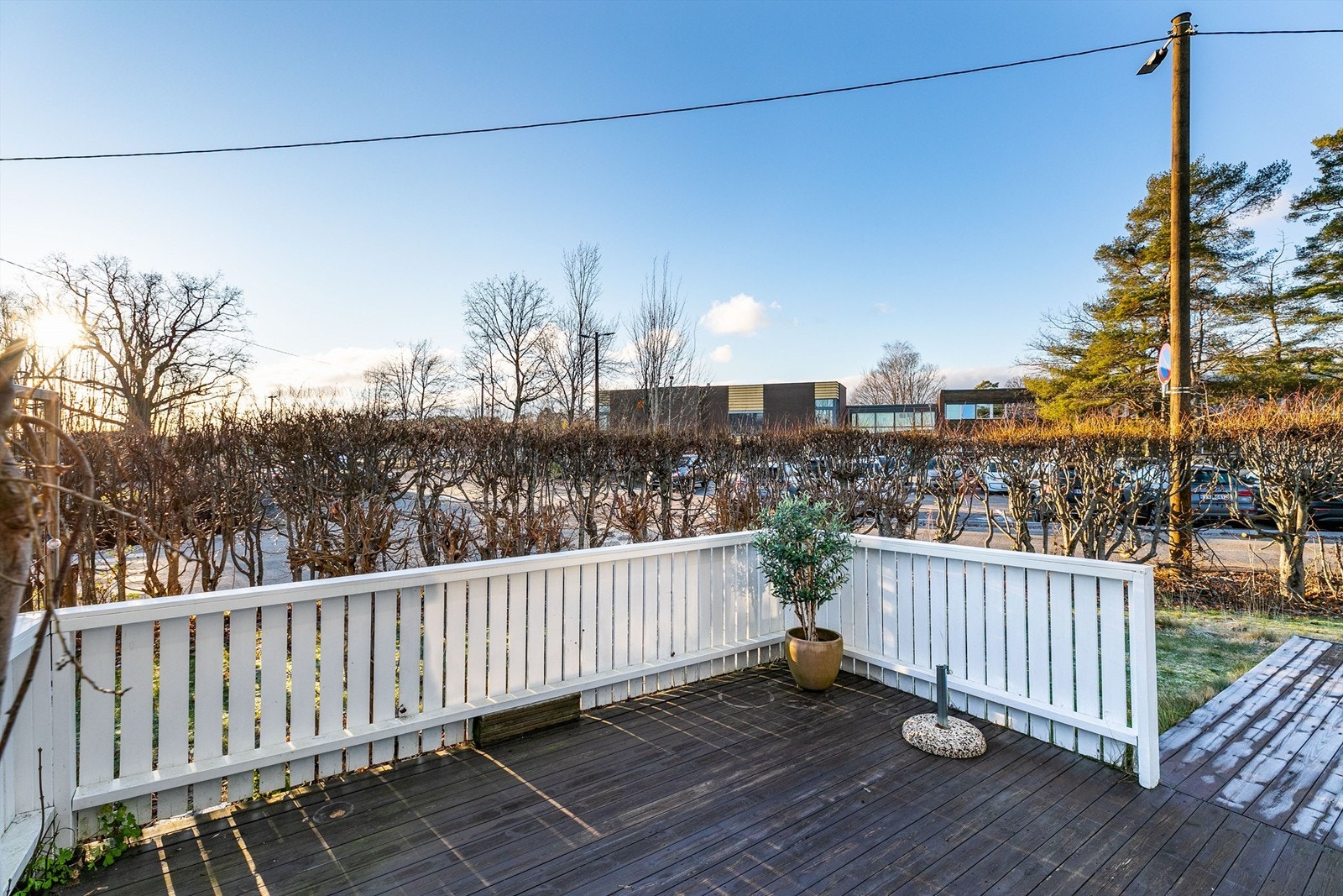 Hekken rundt hagen er i årets varme måneder fylt av grønne blader som begrenser innsyn til terrassene. Hagen er per definisjon fellesareal. Galleribilde