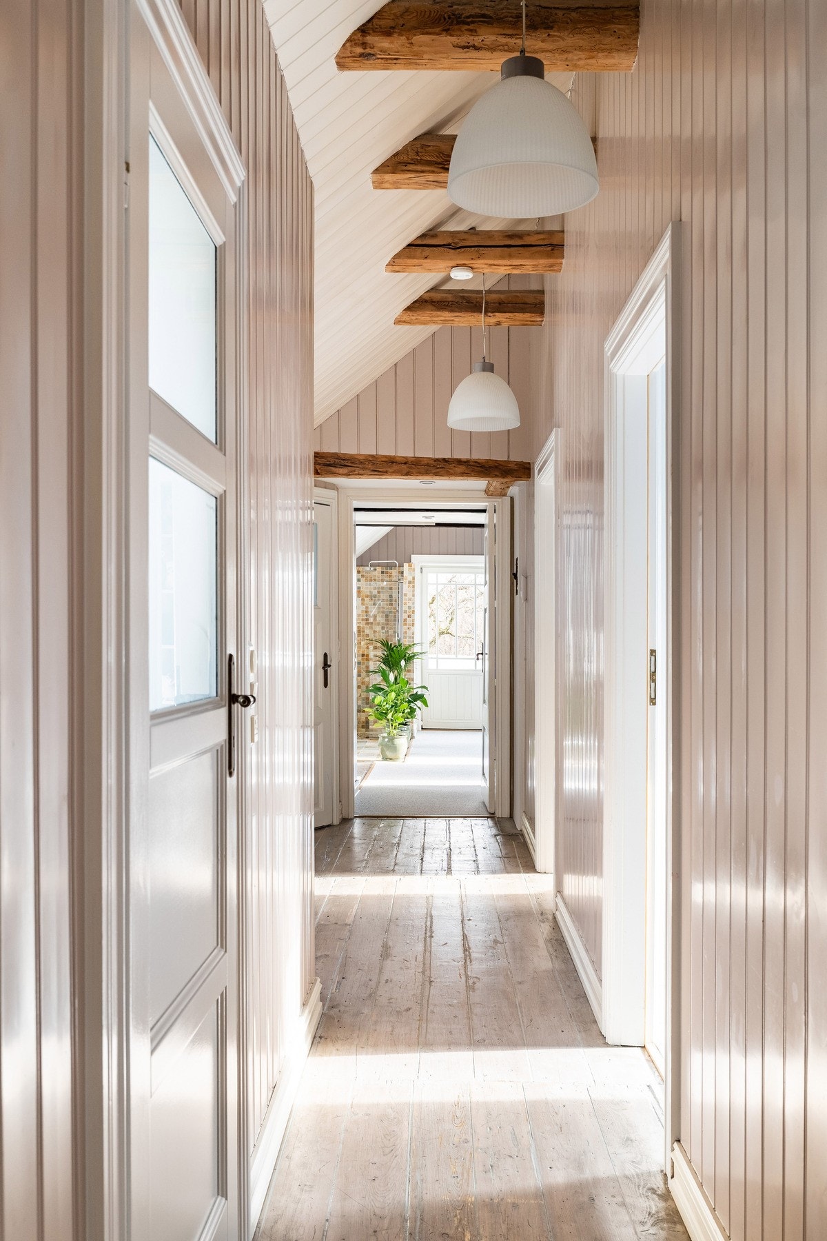 Gangen i loftsetasjen, der de originale 1700-talls tregulvene og takbjelkene gir en varm og innbydende følelse. Galleribilde
