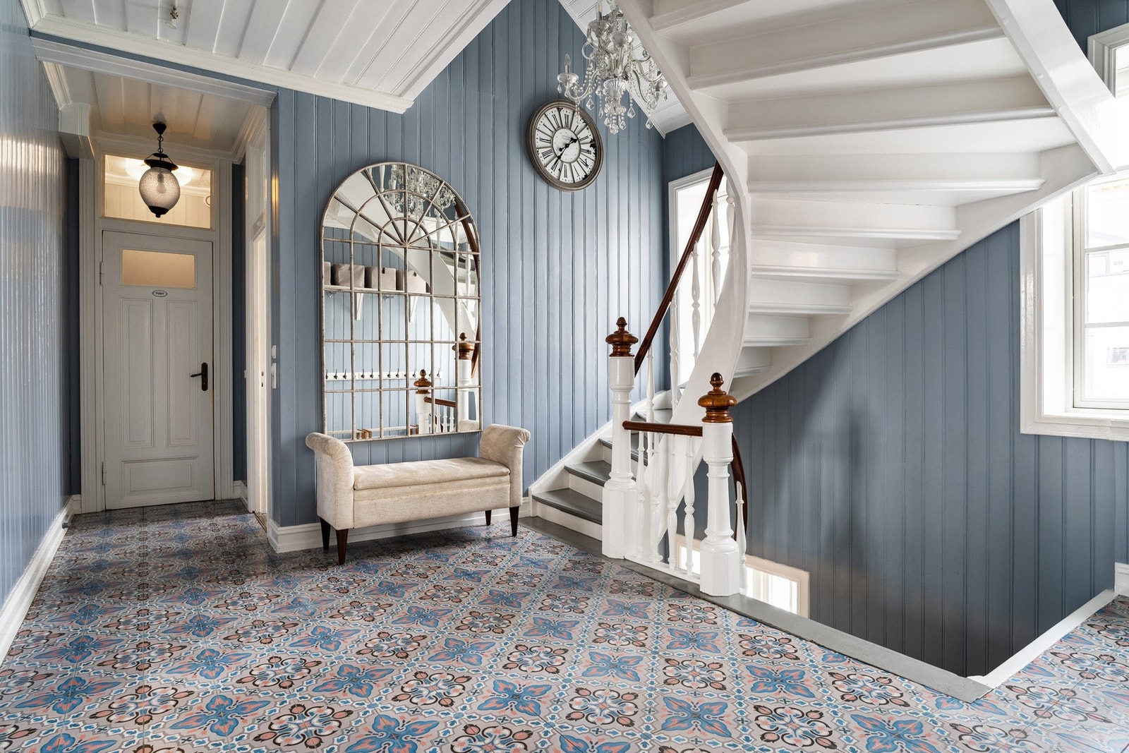 En vakker hall/entré med unike, spesialdesignede fliser og praktisk tilgang til et toalett. Galleribilde