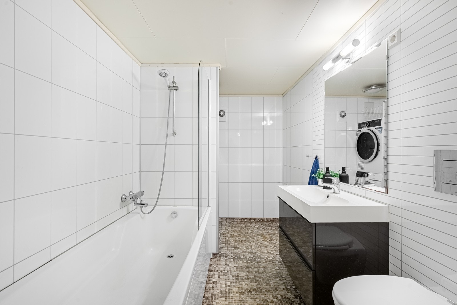 Bad/vaskerom. Innredet med vask i seksjon, vegghengt toalett, badekar og opplegg for vaskemaskin og tørketrommel. (ikke godkjent) Galleribilde