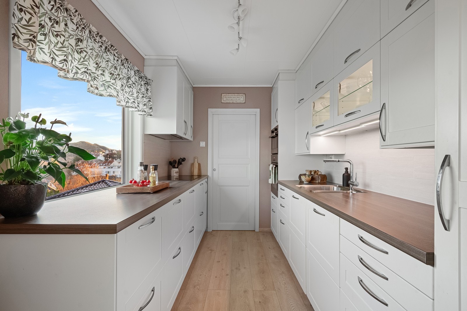 Innholdsrikt kjøkken som har godt med skap og benkplass. Galleribilde