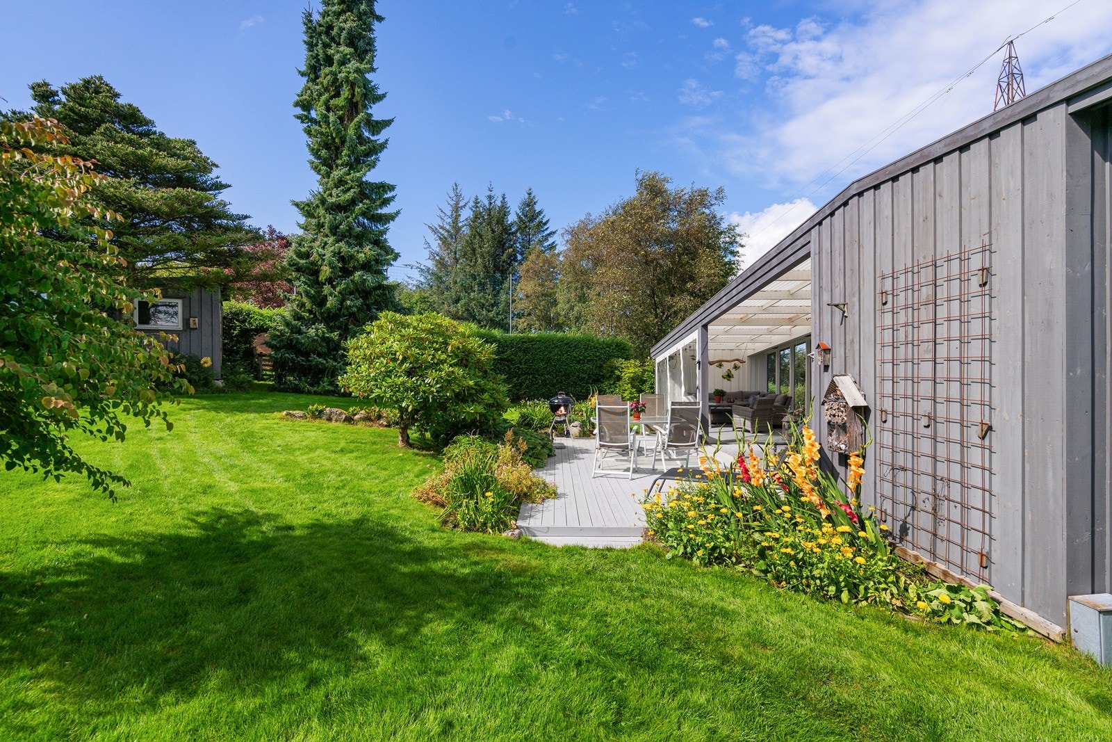 Tomten er meget pent opparbeidet med terrasse, plen og beplantning. Galleribilde