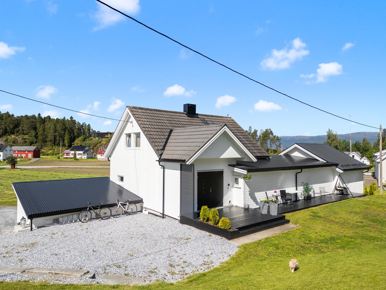 Fasadebilde bak huset - opparbeidet med platt og plen rundt. Galleribilde