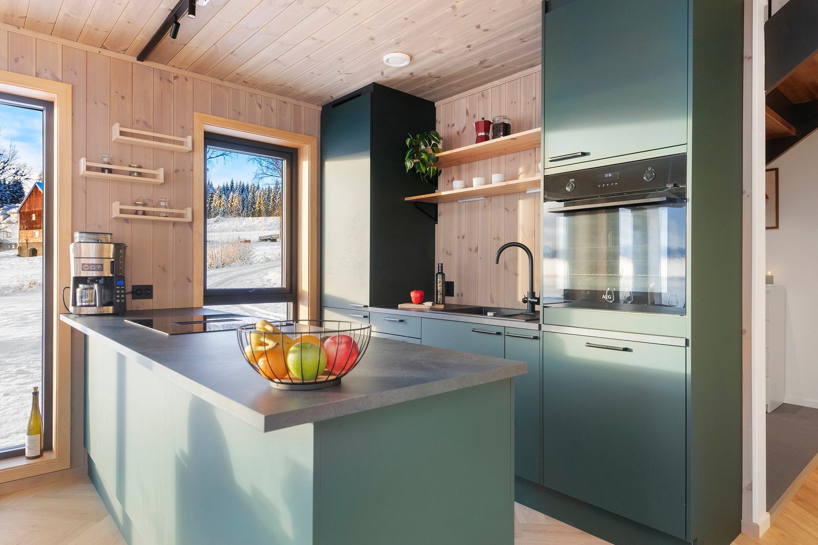 Kjøkken med kjøkkenøy og integrert stekeovn, platetopp, oppvaskmaskin og kjøl-/fryseskap. Galleribilde