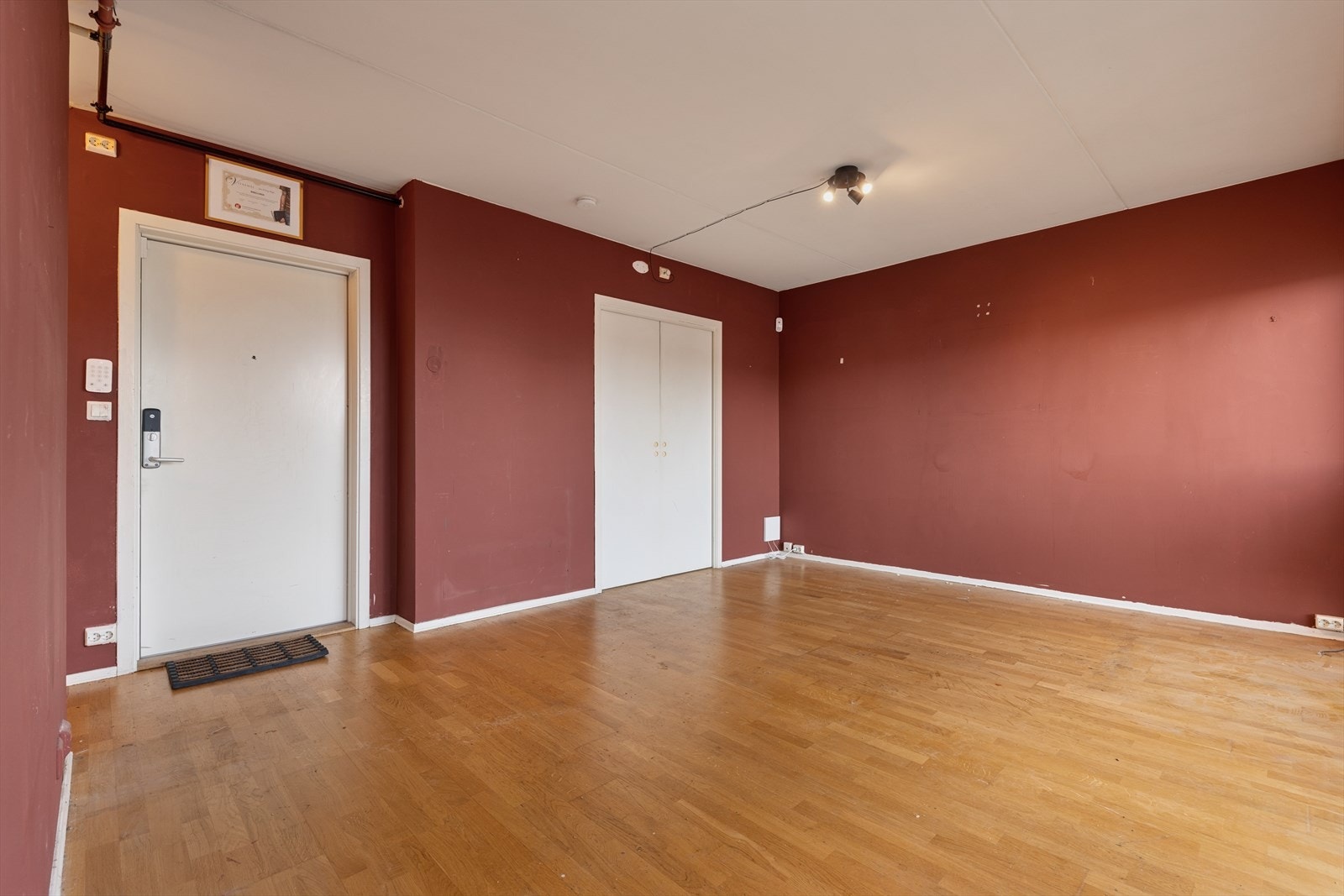 Stuen er utført med parkettgulv, malte veggflater og betonghimling - Innvendig fremstår leiligheten med noe moderniseringsbehov, men her ligger mye til rette for å skape din drømmeleilighet Galleribilde