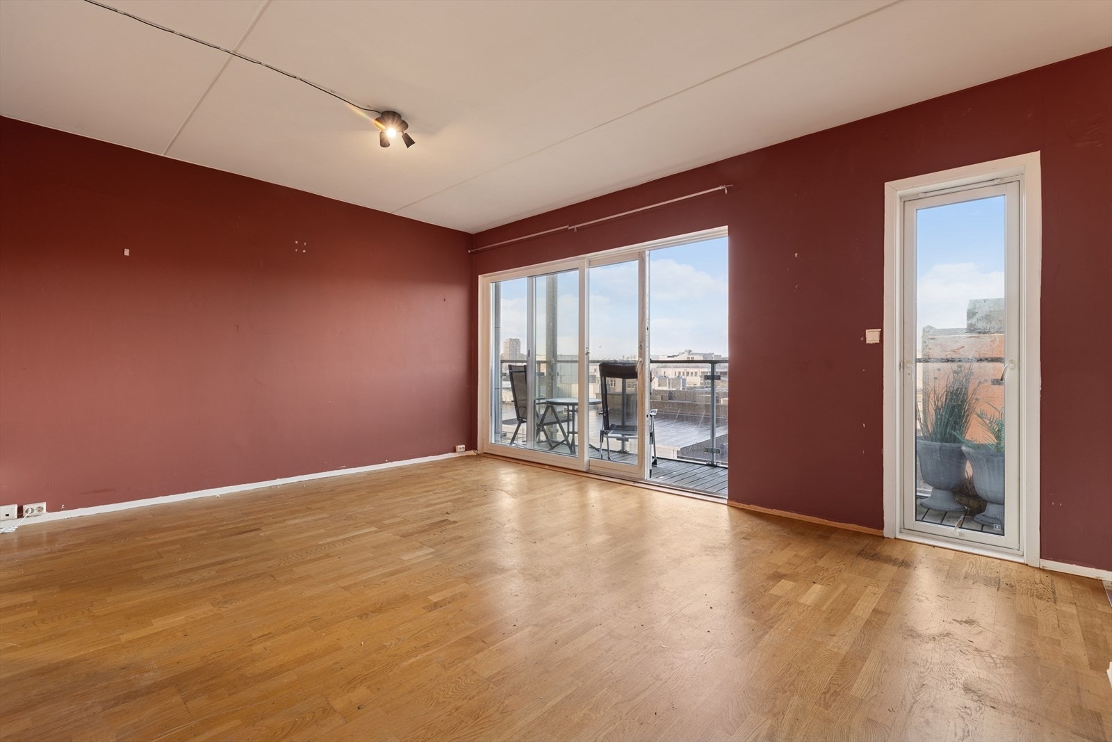 Det er store vindusflater som slipper inn rikelig med dagslys, samt skyvedør i glass ut til balkongen Galleribilde