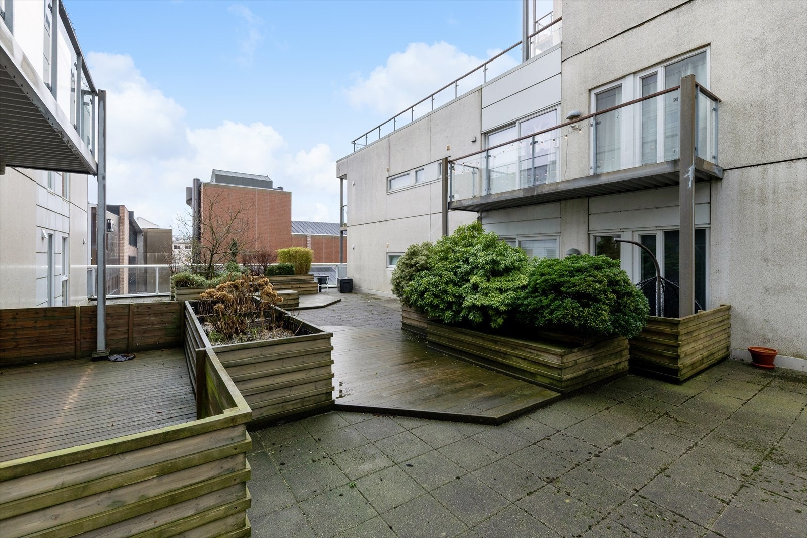 Felles takterrasse i 3. etasje med beplantning og sitteplasser Galleribilde