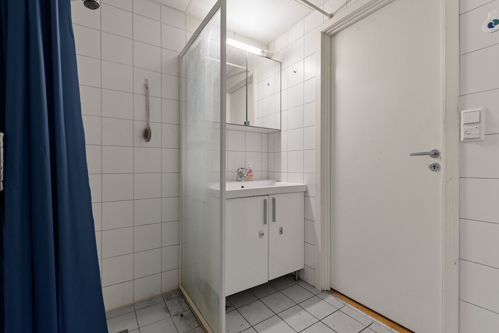 Badet er flislagt med nøytrale fargevalg og har varme i gulvet Galleribilde