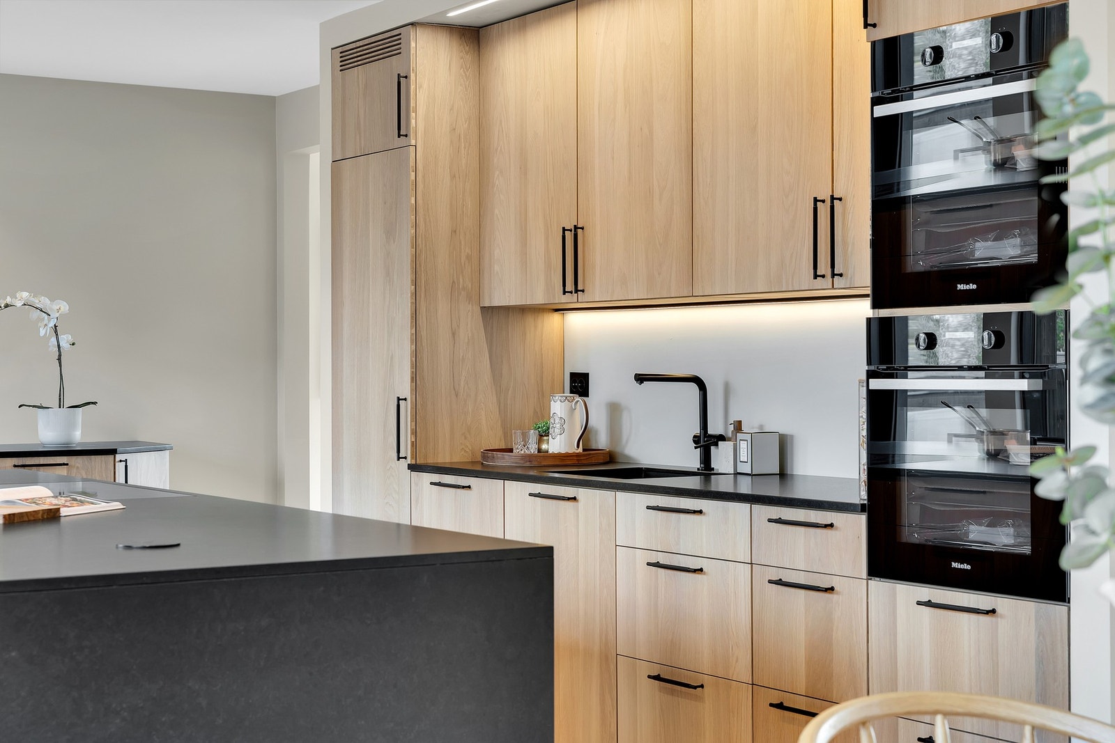 Integrerte kvalitetshvitevarer består av to stekeovner i praktisk høyde, platetopp, kjøl-/fryseskap og oppvaskmaskin. Galleribilde