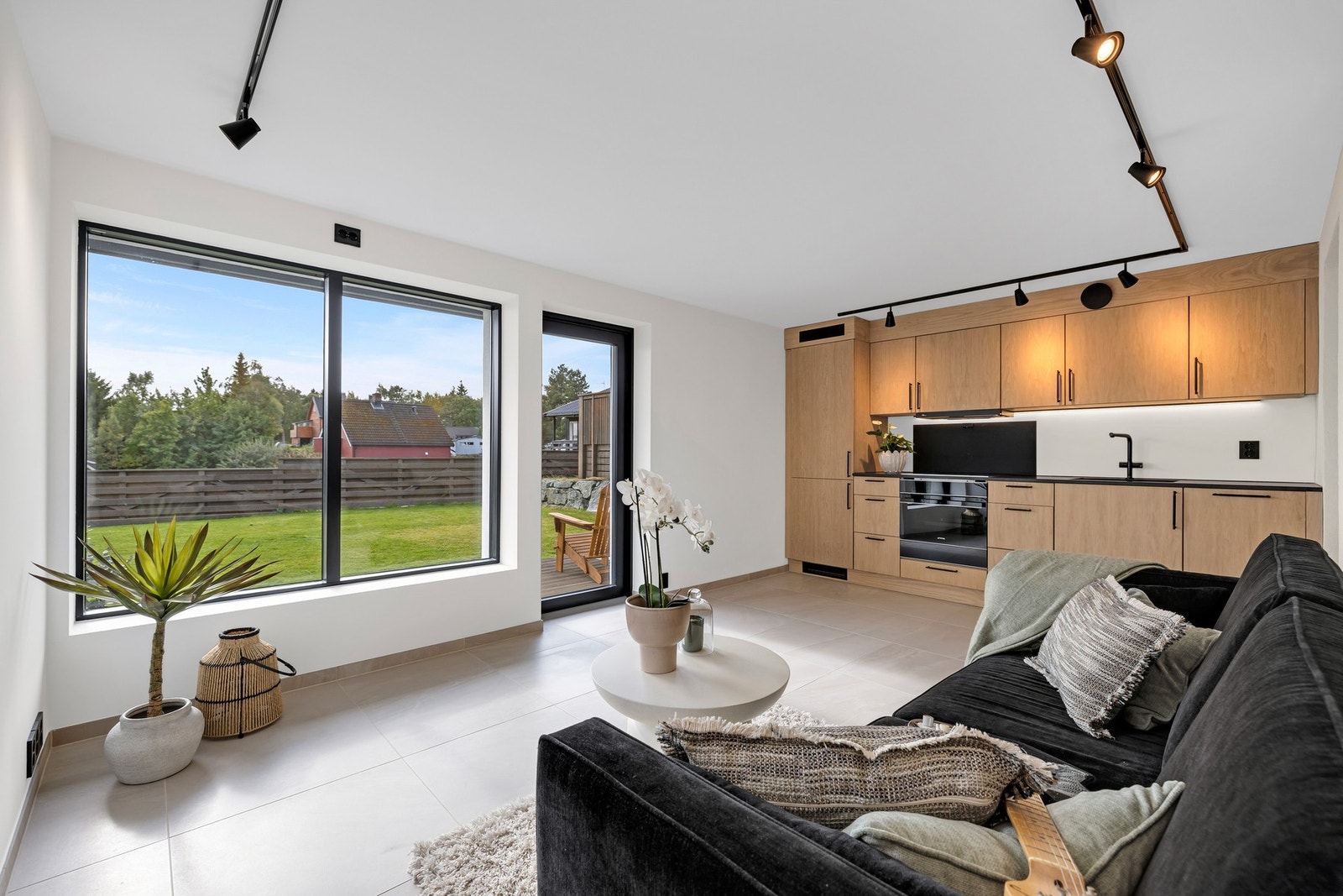 Åpen stue-/kjøkkenløsning på 15,8 kvm. Moderne kjøkken med steinbenkeplate og integrerte hvitevarer. Galleribilde