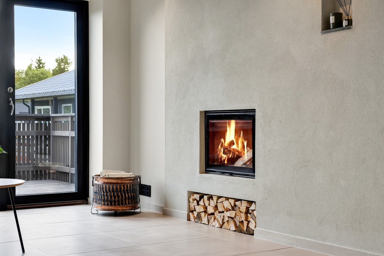 Koselig, integrert peis med dekorativ vedhylle. Boligen har også en effektiv vannbåren bergvarmepumpe. Galleribilde