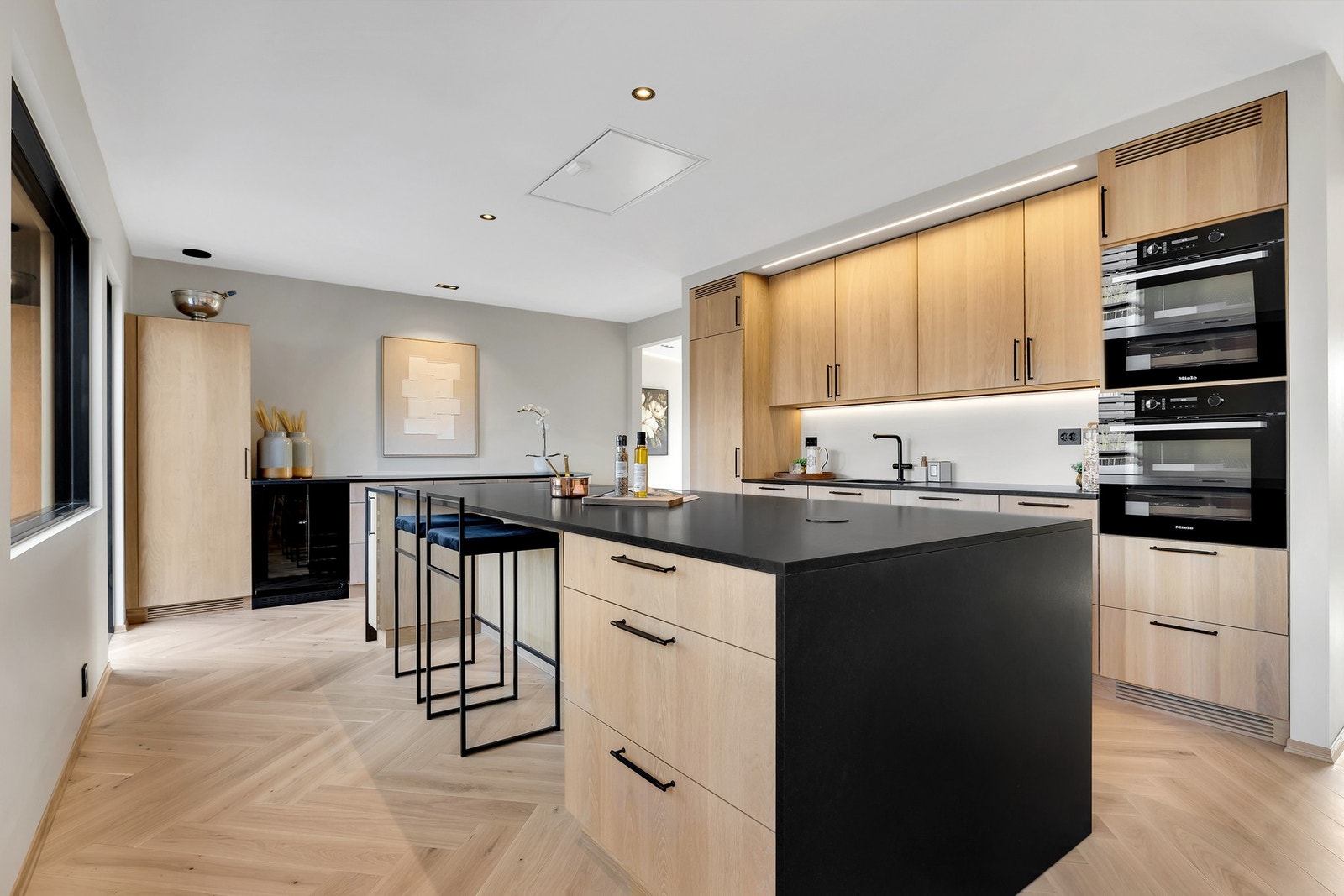 Det er montert vinskap i kjøkkeninnredningen langs veggen, og ellers er det god oppbevaringsplass til både kjøkkenutstyr, servise og tørrvarer. Galleribilde