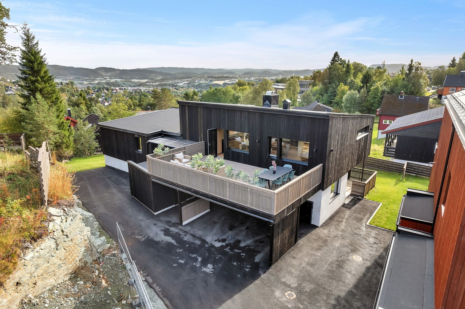 Romslig, asfaltert gårdsplass med oppstillingsplasser til begge hyblene. Galleribilde