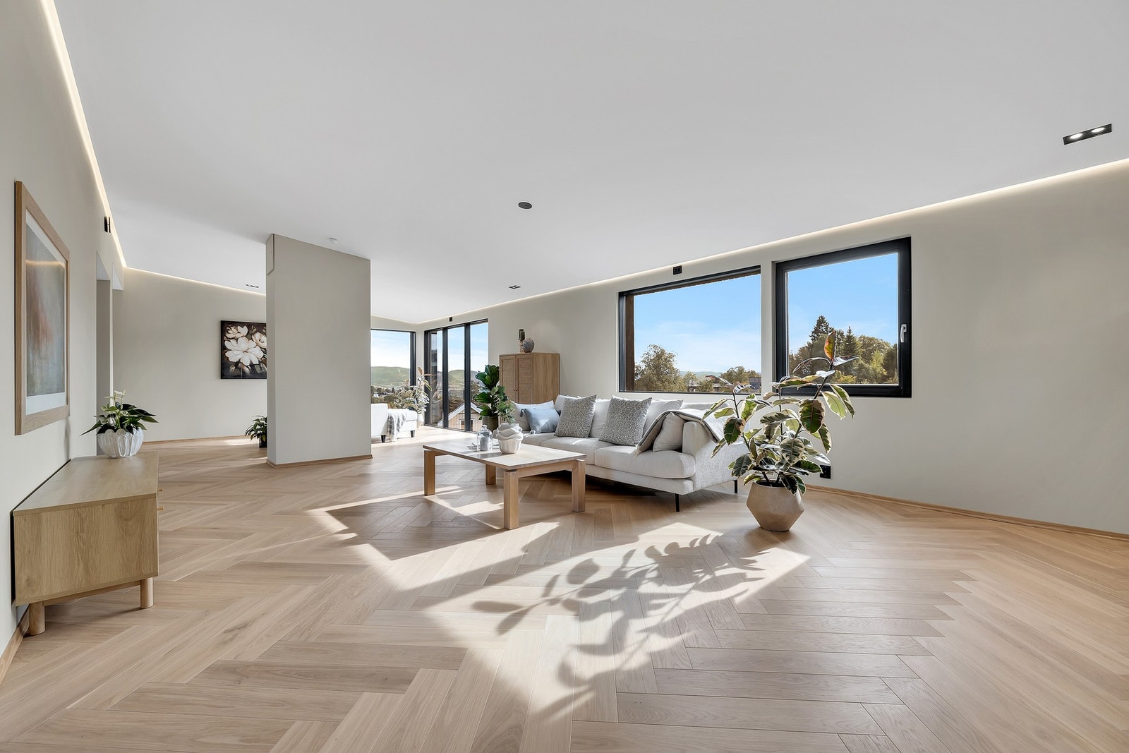 Luftig og gjennomslys stue på hele 50,3 kvm med lekker fiskebensparkett og skjult, indirekte ledbelysning. Galleribilde