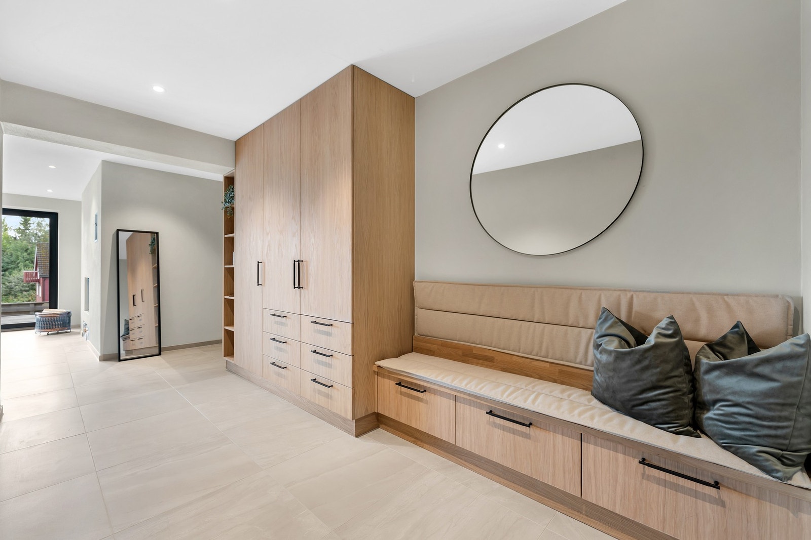 Stilig garderobeløsning plassbygd av møbelsnekker gir et ryddig og uttrykk og har praktisk oppbevaring for hele familien. Praktisk og dekorativ sittebenk integrert i løsningen. Galleribilde