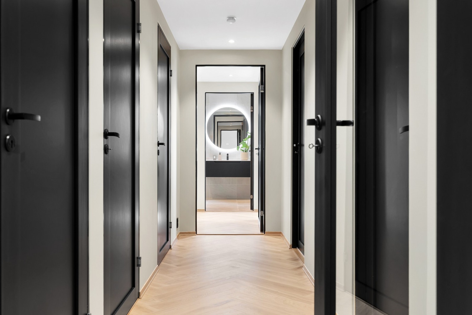 Mellomgang med tilgang på WC, bod, to bad, tre soverom og omkledningsrom. Galleribilde