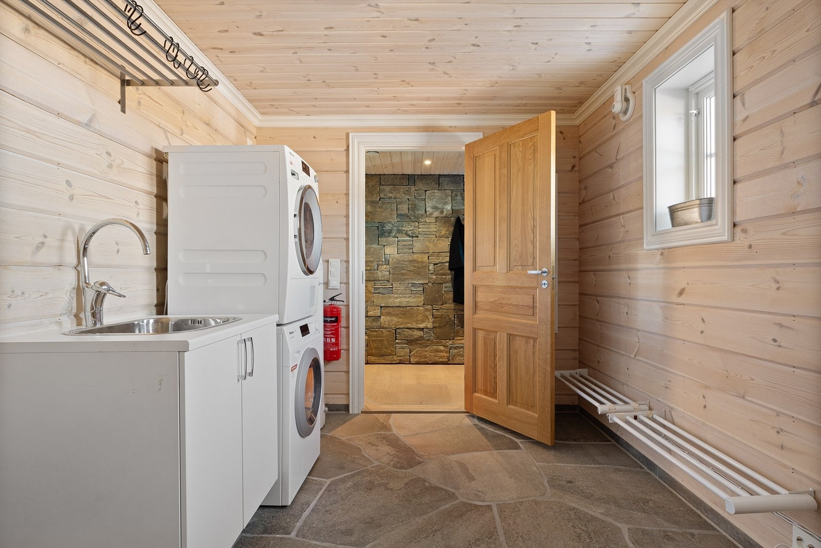 praktisk vaskerom med god plass til klær og utstyr. Her er det utslagsvask. Skifer på gulv og rikelig med tørkeplass. Galleribilde
