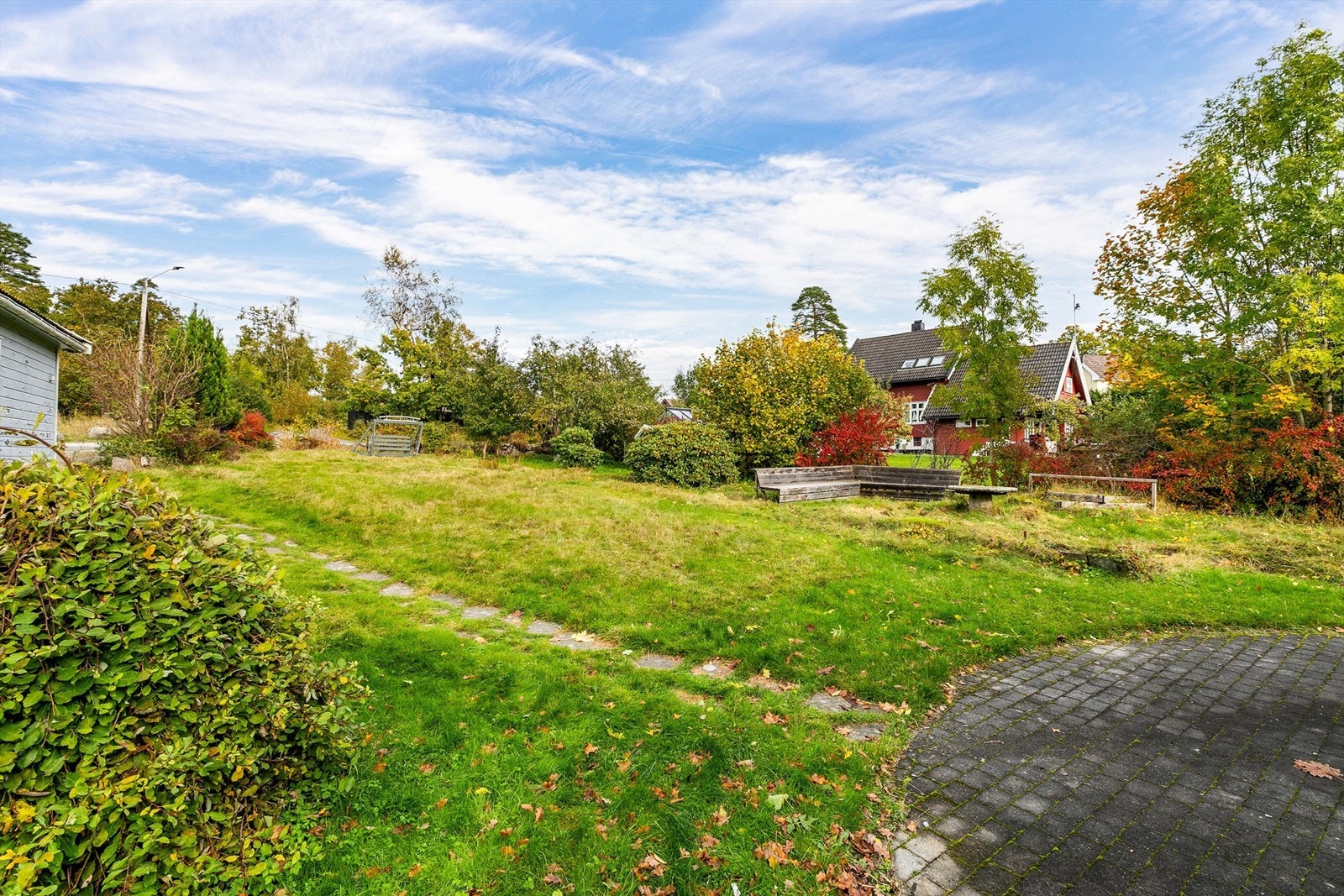 Tomtegrense syd går umiddelbart foran gangarealet utført med belegningsstein, tilhørende naboeiendom. Galleribilde