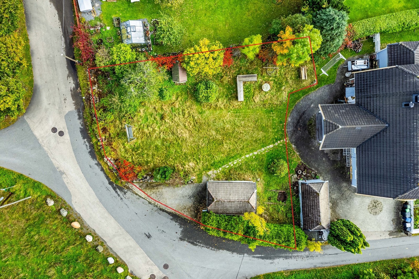 Rød linje viser omtrentlig grense. Kommunen ønsker at ny adkomst til tomten legges lengst øst eller lengst syd. Tomten er her sett med vest mot nedre bildekant. Tomtegrenser på bilder er kun ment som en ca gjengivelser Galleribilde