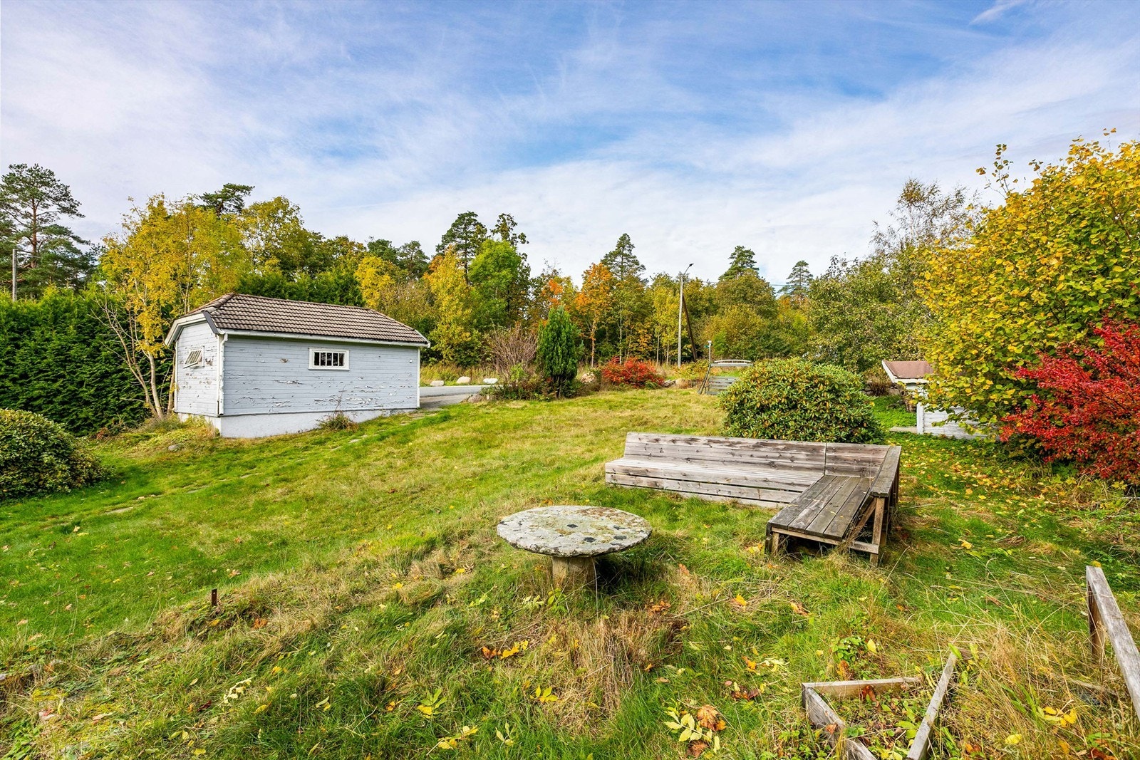 På tomten står en garasje av eldre årgang som i dag er i enkel forfatning. Terrenget er svakt skrånende, høyest i nord. Galleribilde