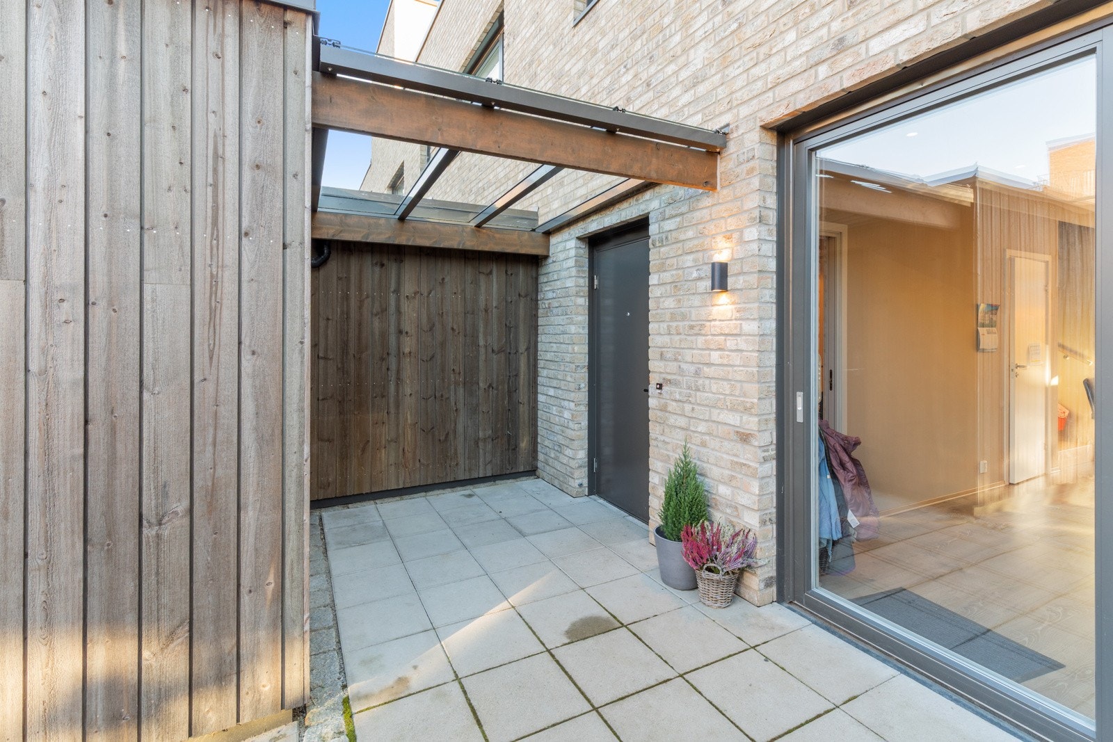 Velkommen inn! Pent, steinlagt inngangsparti | Overbygget inngangsparti med praktisk plassering av sportsbod Galleribilde