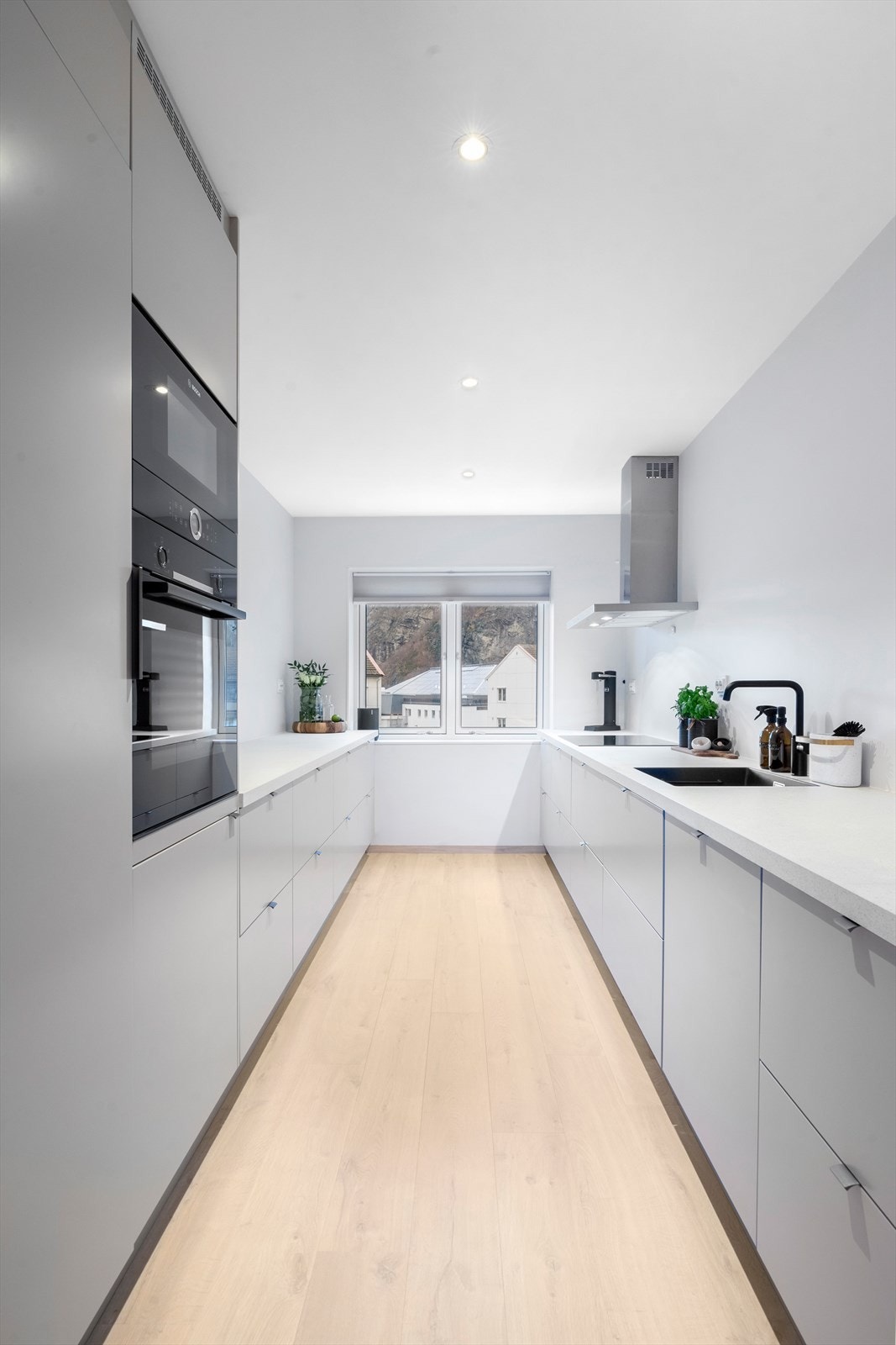 Integrerte hvitevarer og lyse, glatte kjøkkenfronter gir et stilfullt og rent uttrykk. Galleribilde