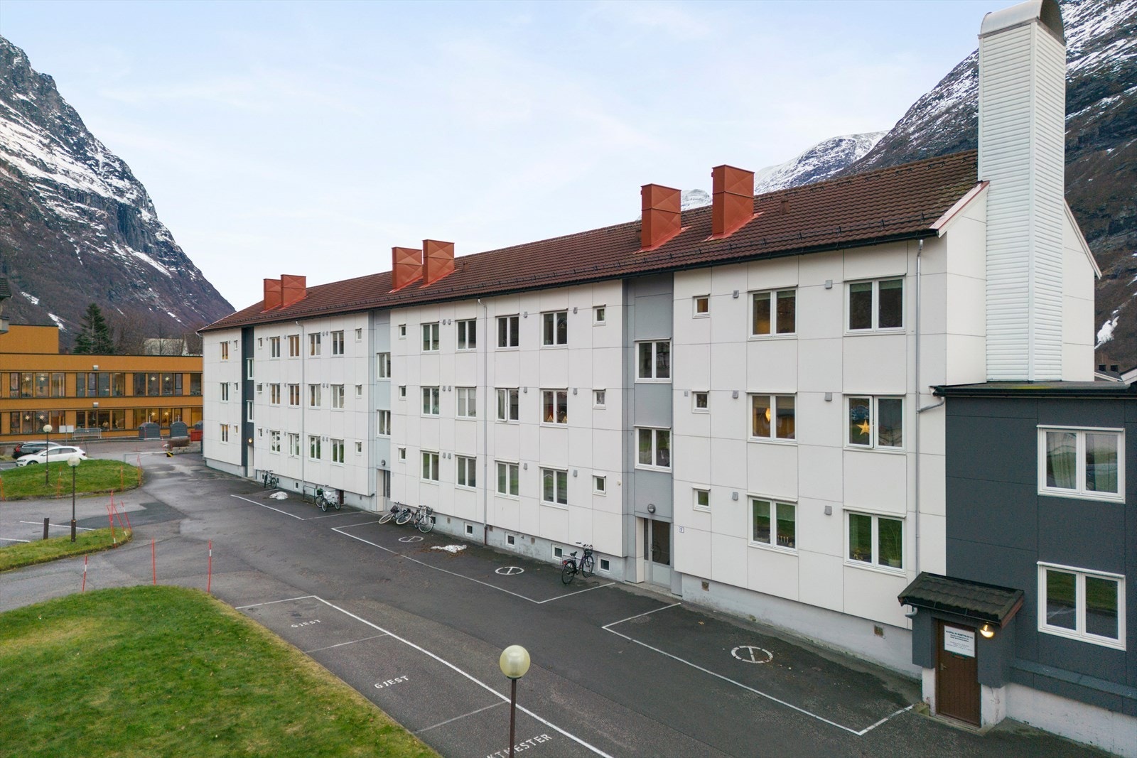 Fleretasjes bygning med flere innganger og parkeringsplasser tilgjengelig. Galleribilde
