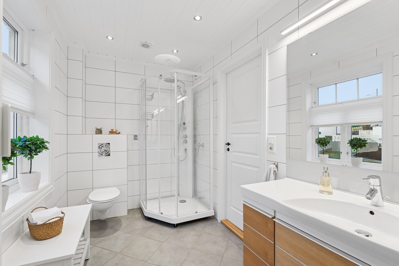 Rommet er av god størrelse og har en stilren innredning med servant, vegghengt toalett, badekar og dusjkabinett. Galleribilde