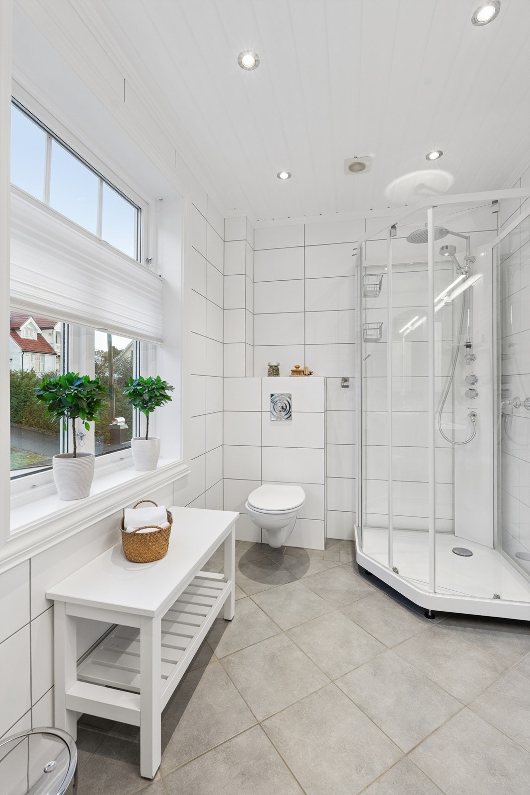 Baderommet i andre etasje er lyst og pent, med fliser på gulv og vegger, samt malt panel i himlingen. Galleribilde