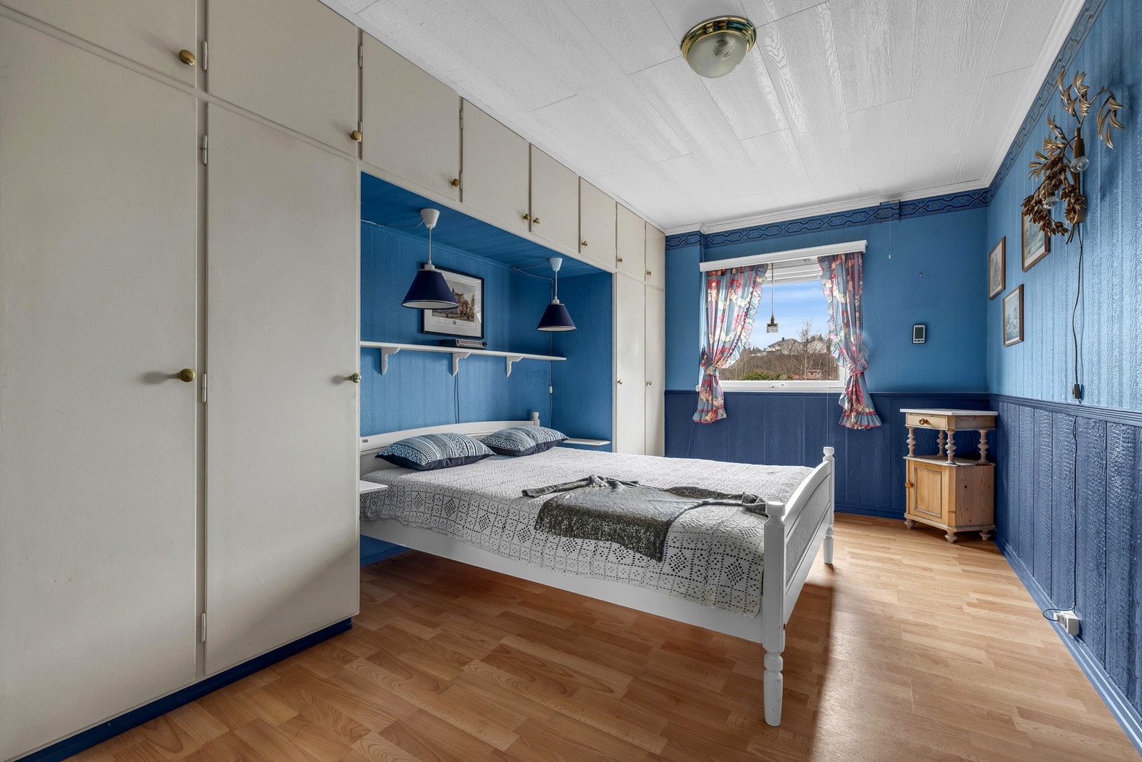 Soverom 2 med innebygde skap, vindu som gir naturlig lys, og vegger malt i blått. Galleribilde