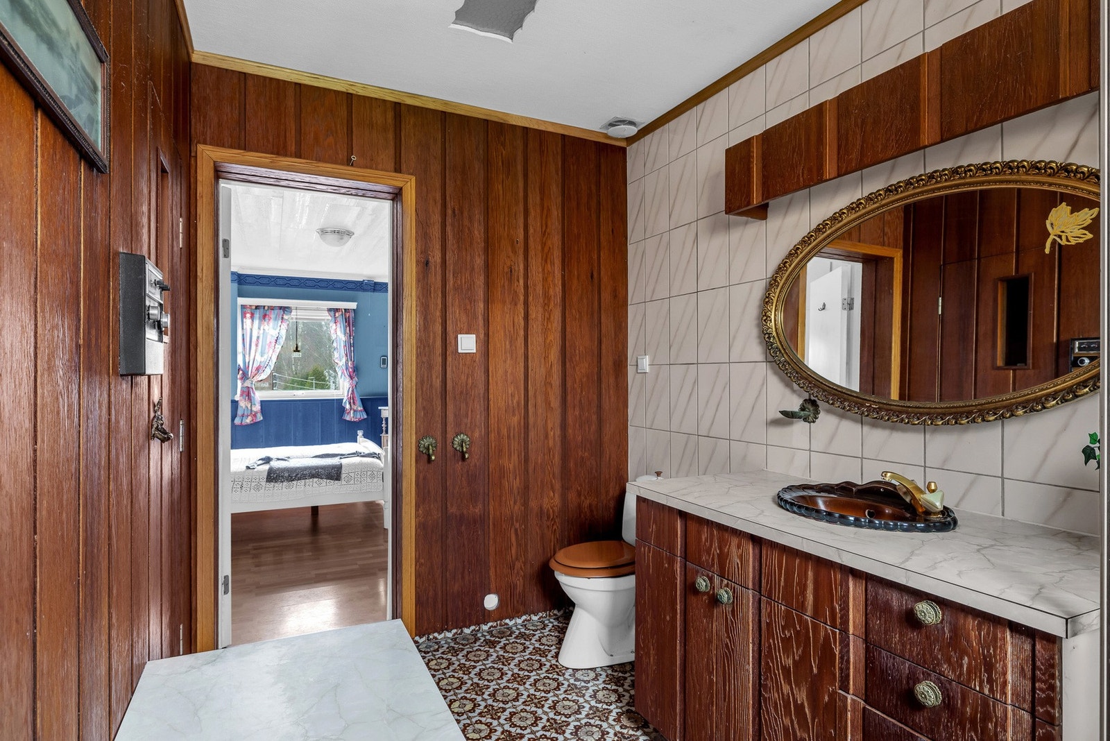 Vegger er delvis flislagt og delvis panelt. Badet ligger i forbindelse med hovedsoverommet. Galleribilde