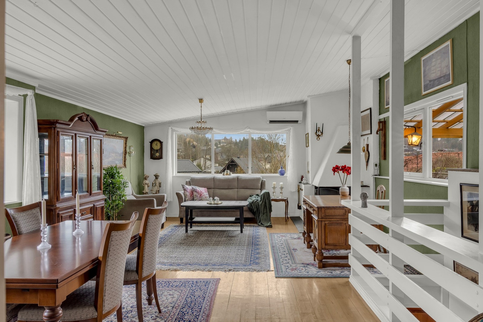 Stue med store vinduer som gir naturlig lys og utsikt mot nærområdet. Rommet har en lys, luftig og innbydende atmosfære. Galleribilde