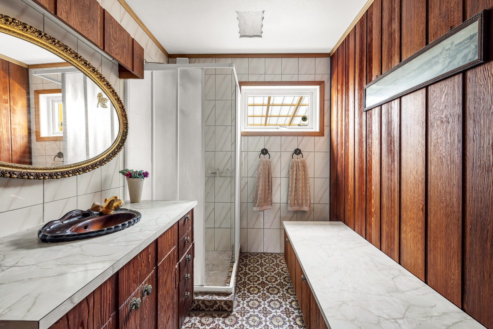 Baderom med dusjkabinett, speil og benkeplate. Galleribilde