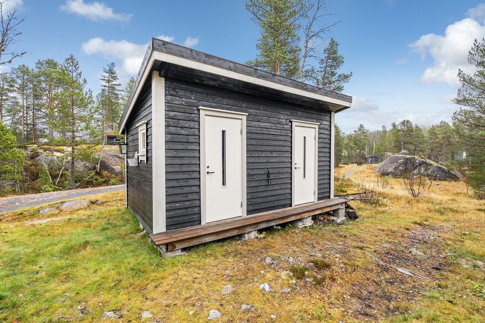 Frittstående stort uthus med bodplass og et innredet rom med seng. Galleribilde