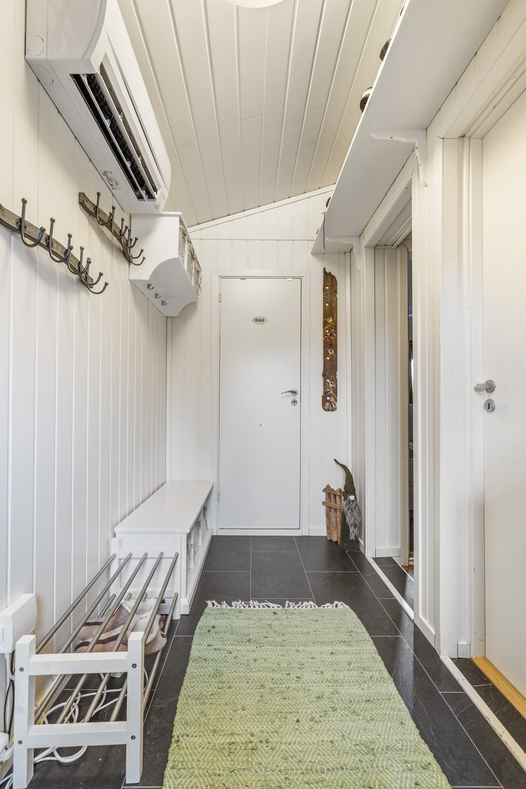 Gangen ved inngangen. Inngang til badet i bakgrunnen. Galleribilde