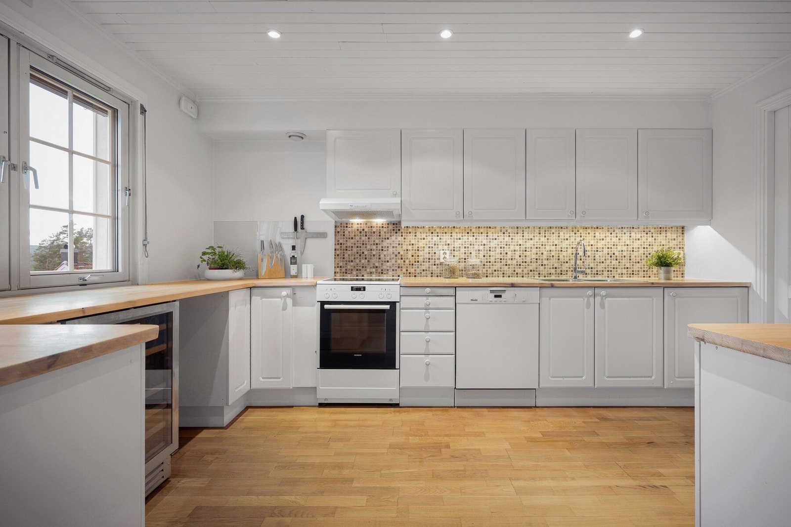 Kjøkkenet er lyst og funksjonelt, med god skap- og benkeplass som gir gode arbeidsforhold i hverdagen. Galleribilde