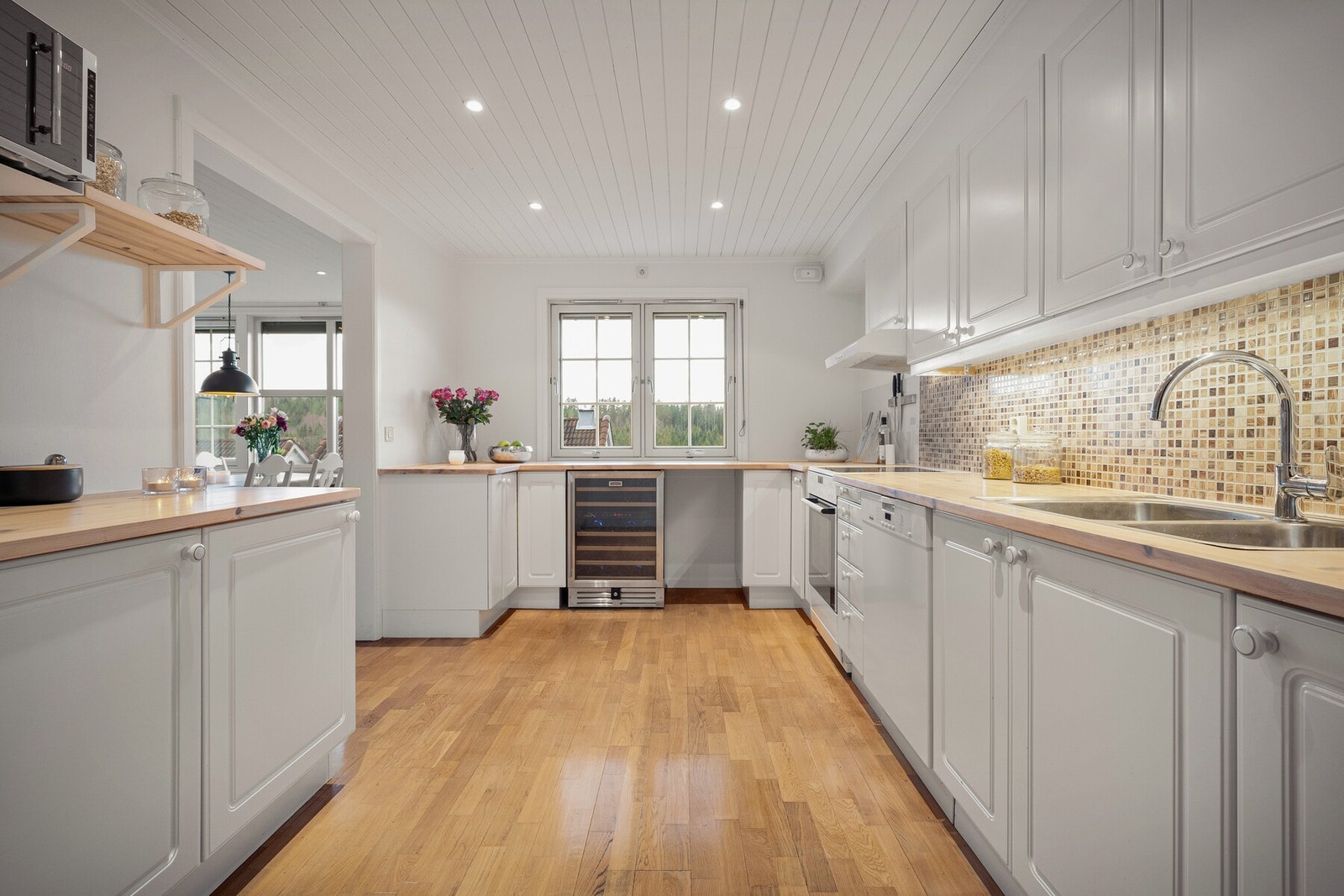 Kjøkkenet har vinduer som gir godt lys over arbeidsområdene, og beliggenheten tett på spisestuen gjør dette til et sosialt kjøkken hvor man enkelt kan lage mat samtidig som man er en del av det som skjer rundt spisebordet. Galleribilde