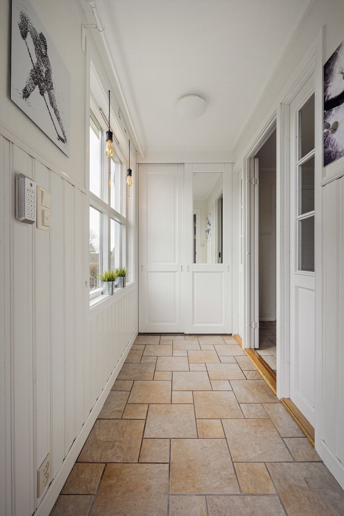 Romslig og lys entré med flislagt gulv og gode oppbevaringsmuligheter. Galleribilde