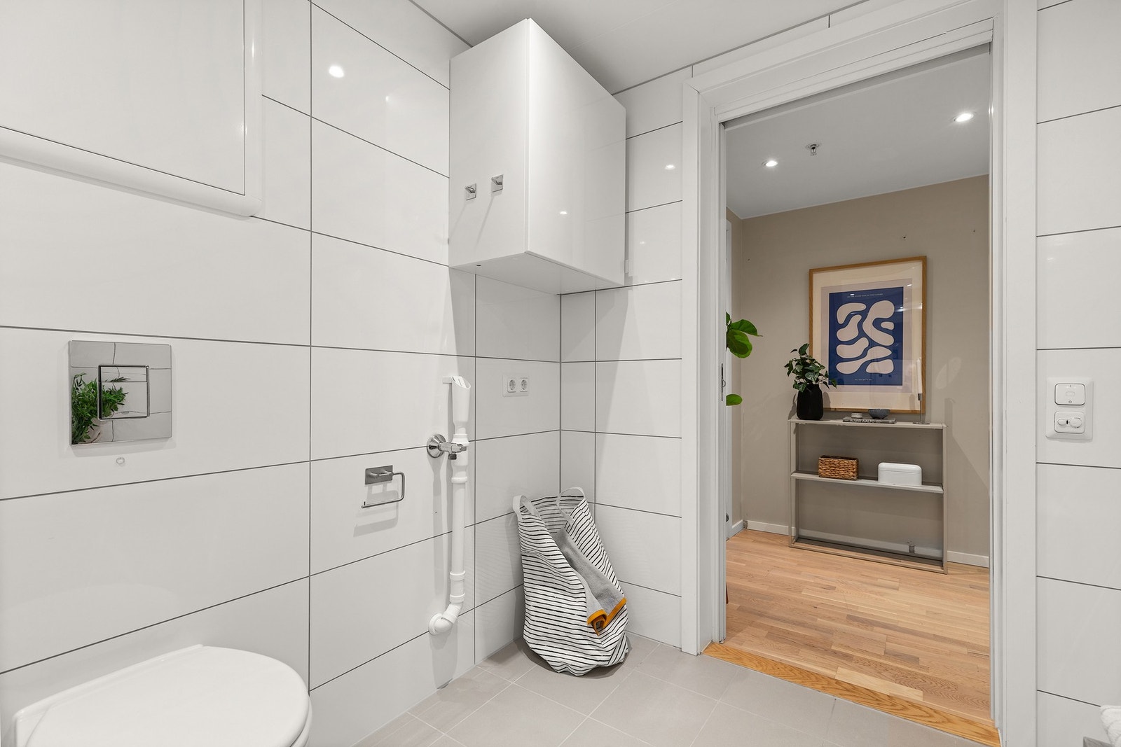 Badet har opplegg for vaskemaskin- Vegger og gulv er flislagt, og rommet er utstyrt med elektriske varmekabler i gulv. Galleribilde