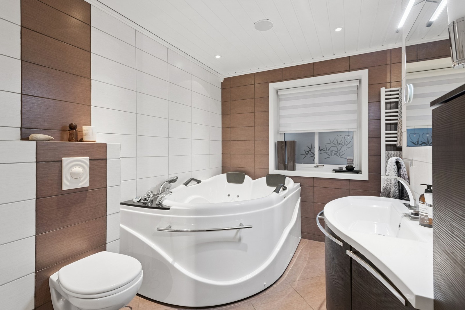 Badet har vegghengt toalett, badekar og dusj. Galleribilde