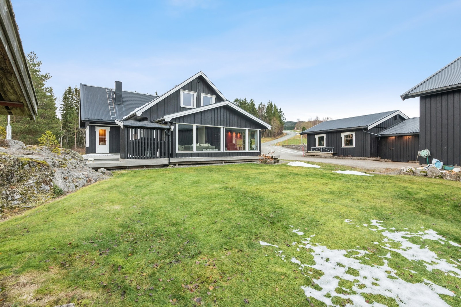 Fra verandaen har man enkel adkomst til romslig plenareal. Innglasset terrasse/hagestue fra 2024. Galleribilde