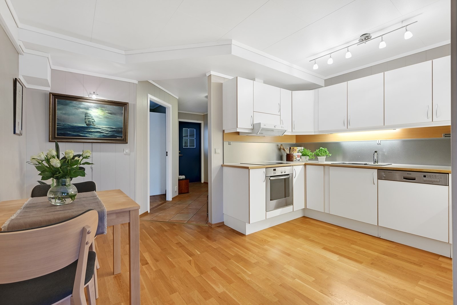 Kjøkken og spisestue med entré og et soverom i bakgrunnen. Galleribilde